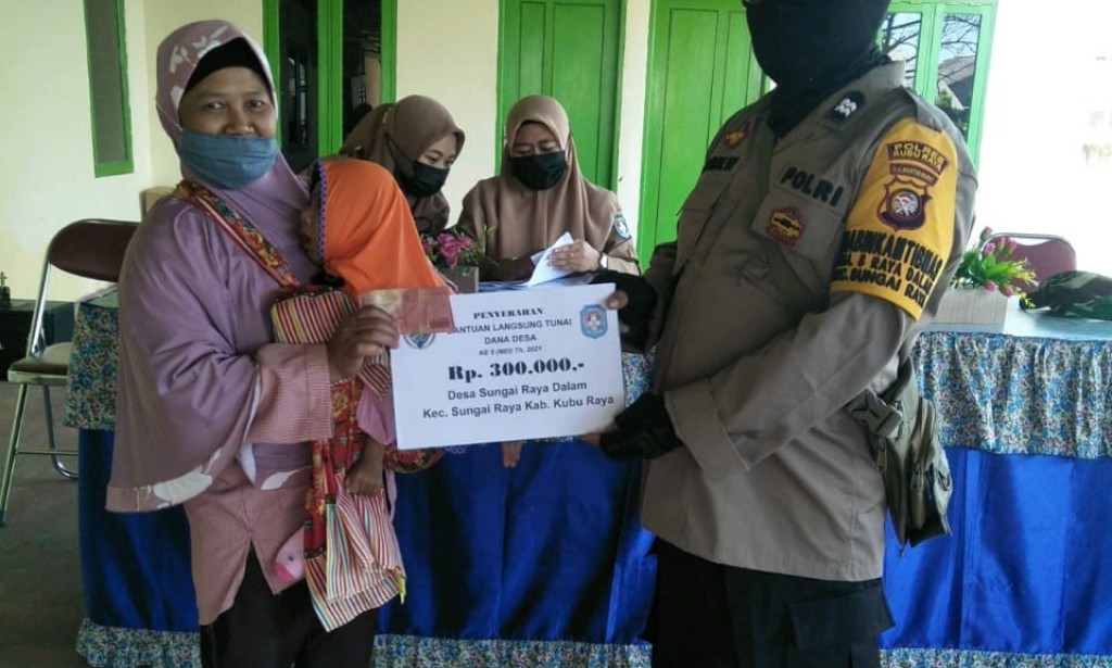 BHABINKAMTIBMAS SUNGAI RAYA DALAM KAWAL PEMBAGIAN BLT DD TAHAP 5 DI KANTOR DESA SUNGAI RAYA DALAM