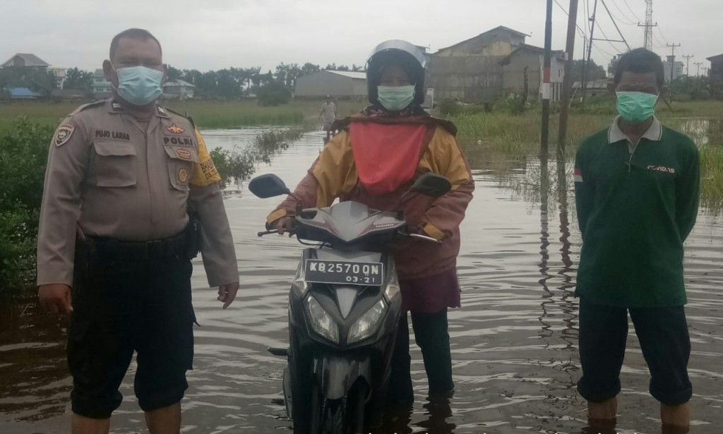 BHABINKAMTIBMAS TELUK KAPUAS PANTAU DESA BINAANYA YANG MENGALAMI BANJIR AKIBAT CURAH HUJAN SEKALIGUS EDUKASI PPKM DARURAT DAN ZONA ORANGE