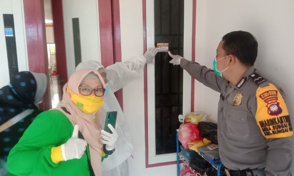 Bhabinkamtibmas Polsek Sungai Raya tempel stiker nomor Satgas Covid 19 di Rumah Pasien Covid 19
