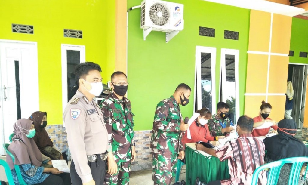 Bhabinkamtibmas Limbung Hadir dalam pelaksanaan Vaksinasi di Aula Kantor Desa Limbung